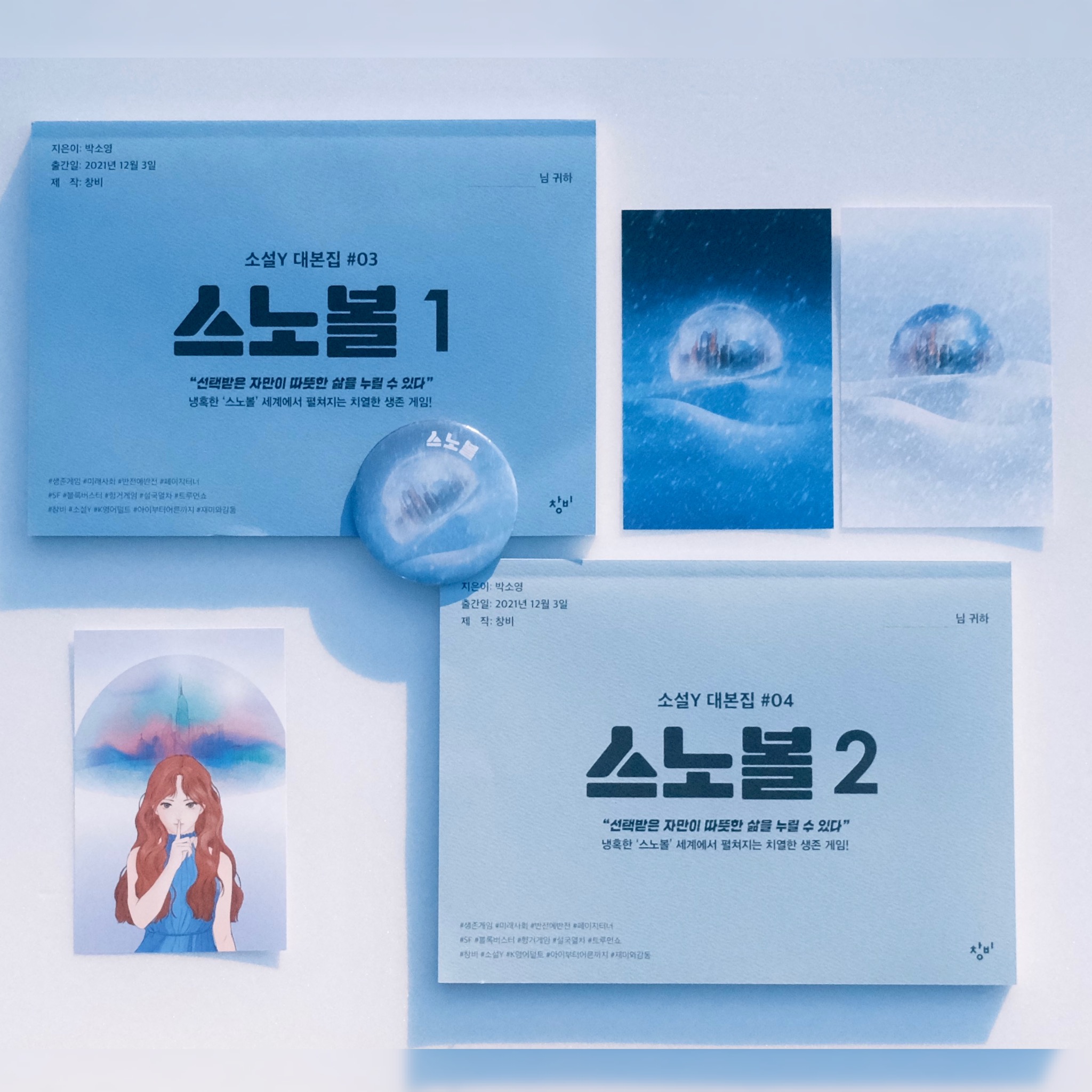 드라마 대본집의 형식을 본따 만든 『스노볼』의 가제본 원고를 찍은 사진. 대본집 표지에는 지은이과 출간일, 제작사 정보와 더불어 “소설Y 대본집 #03 스노볼 1”이라는 제목이 쓰여 있다. 사진에는 두 권의 대본집 외에도 뱃지, 작은 포토카드 등이 함께 찍혀 있다.